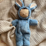 Olli Ella cozy dinkum bunny twiggy doll in blue colour lying on top of a soft blanket. This fluffy toy doll is available at Babipur