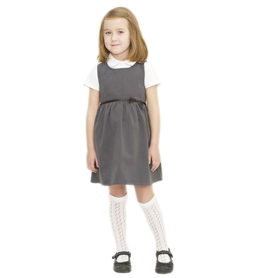 A little girl wearing the Eco Outfitters organic and fair trade cotton school pinafore dress in grey.