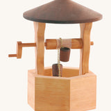 Ostheimer handmade, wooden wishing well with a dark brown wooden roof. This wishing well has a moving handle which pulls two small wooden buckets up and down on a gold metal chain
