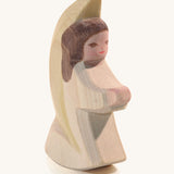 A wooden white Ostheimer little angel figure on a cream background.