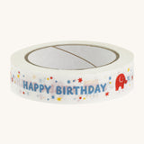 Happy birthday paper tape on a cream background.