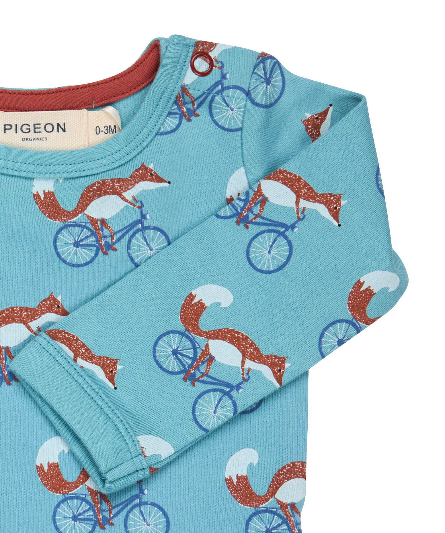 A close up of the Pigeon Organics turquoise cycling fox sheep body showing the popper fastener detail on the shoulder