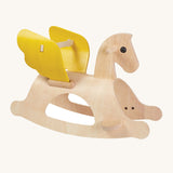 The PlanToys Rocking Pegasus, is a beautiful first rocking horse made from wood with the natural wood grain showing through, yellow wings and a back support between both wings. The image is on a cream background