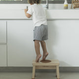 Child in stood on a Hevea Rubberwood Step Stool reaching into a sink.