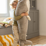 A child playing and holding the Senger Giant grey whale available at Babipur. A soft and cuddly giant whale toy in grey with playful facial features