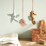 A closer look at the details on the Roommate Sealife Hanging Mobile. The blue starfish has sleepy eyes and dark blue spots. The Pink shell has sleepy eyes and white shell lines, and the sea horse is wide awake with light blue fins on its back