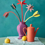 Studio Roof cardboard bouquet in blooming abundance colour way available at Babipur. A DIY kit made from cardboard displayed in a homemade paper mache vase next to a watering can