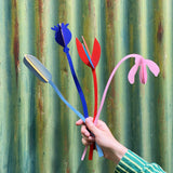 A hand holding a bunch of the Studio Roof cardboard bouquet from the giant set showing scale. This set is available at Babipur.