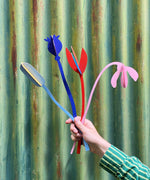 A hand holding a bunch of the Studio Roof cardboard bouquet from the giant set showing scale. This set is available at Babipur.