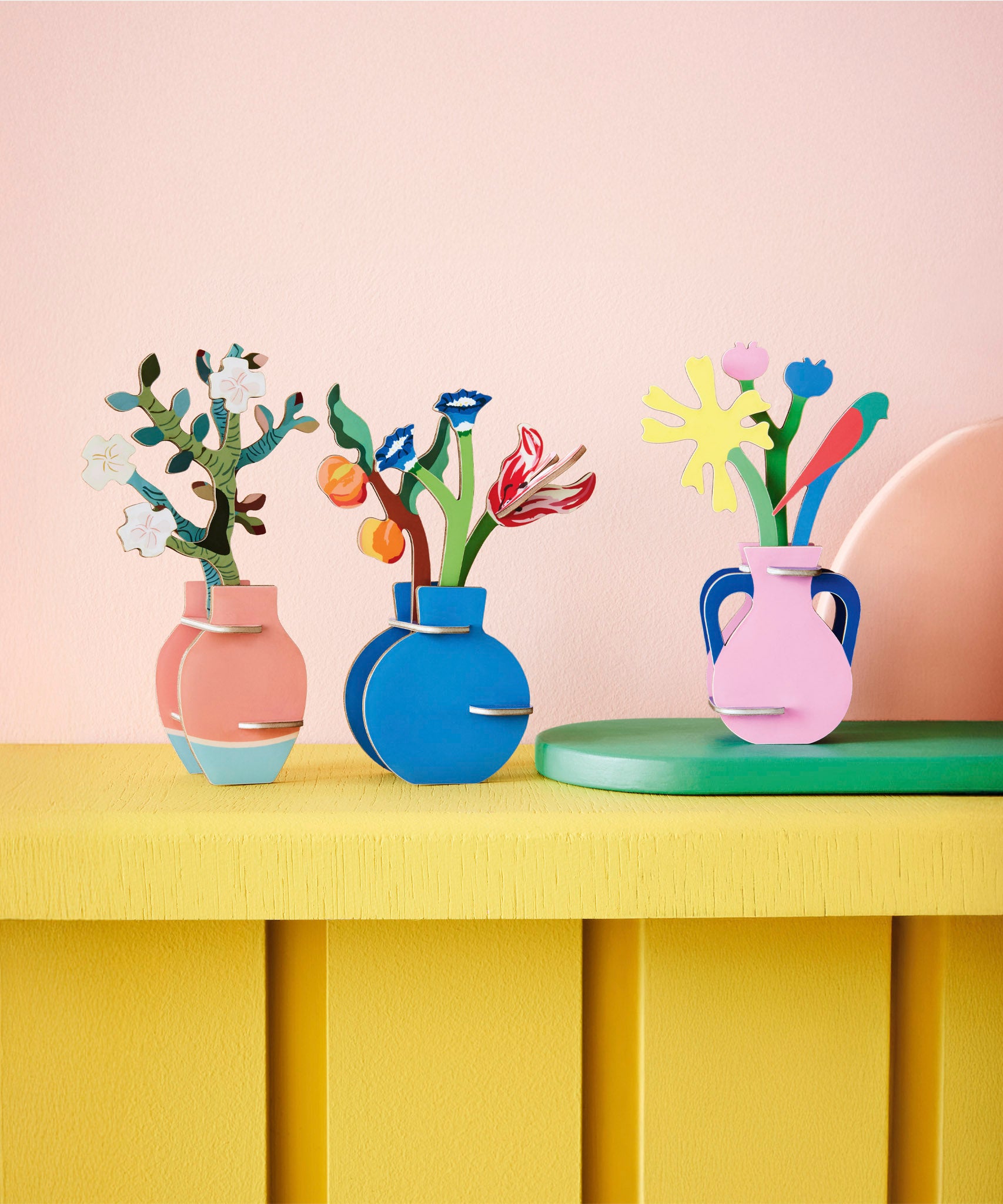 A group of Studio roof 3D pop out card bouquets decoration standing on a yellow wooden table available at Babipur