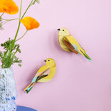 Studio Roof citrinella pair wall decorations available at Babipur hanging on a light purple wall with a glass vase in front