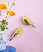 Studio Roof citrinella pair wall decorations available at Babipur hanging on a light purple wall with a glass vase in front