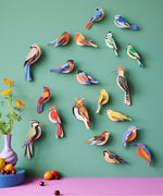 A group of Studio Roof garden birds hanging decorations on a  green wall available at Babipur including the brown tawny owl