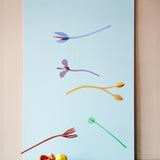 A Studio Roof cardboard Cordelia floral art mobile hanging over a table. This multicoloured floral DIY cardboard set is available at Babipur.