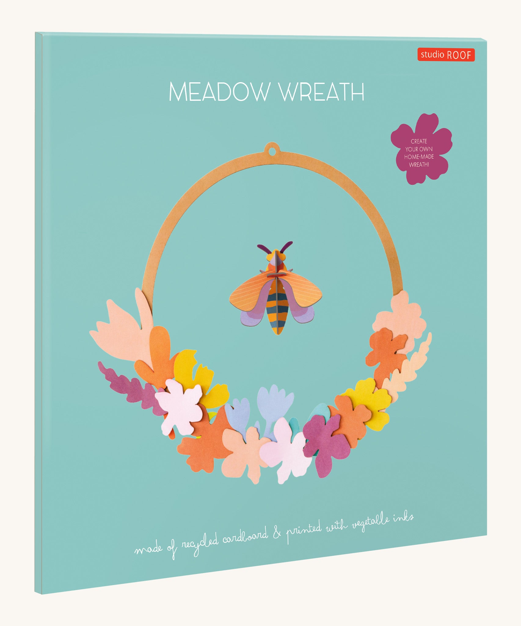 The pastel coloured packaging presenting the Studio Roof wreath meadow with bee available at Babipur.