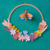 A close up of the Studio Roof wreath meadow with bee available at Babipur. showing the different coloured flowers on the wreath.