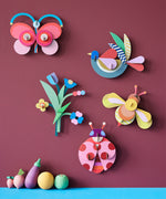 A group of wall decorations from the collaboration with Studio Roof and Zoe Miller available at Babipur. Decorations are hanging on a wall above wooden vegetables