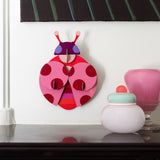 A close up of the dotted lady wall decoration available at Babipur hanging on a wall above a mantlepiece