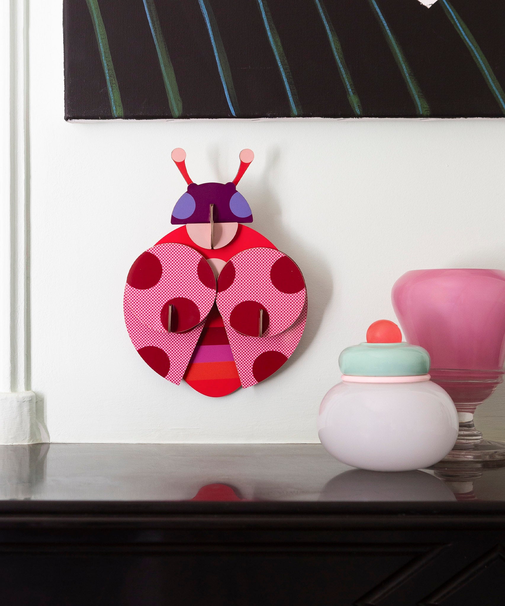 A close up of the dotted lady wall decoration available at Babipur hanging on a wall above a mantlepiece