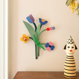 Daisy belle wall decoration available at Babipur hanging on a wall above above a wooden drawer next to a giant wooden peg doll. A Studio roof collaboration with artist Zoe Miller.