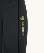 A close up of the Wildride premium shoulder pad in black available at Babipur showing the velcro and brand logo detail