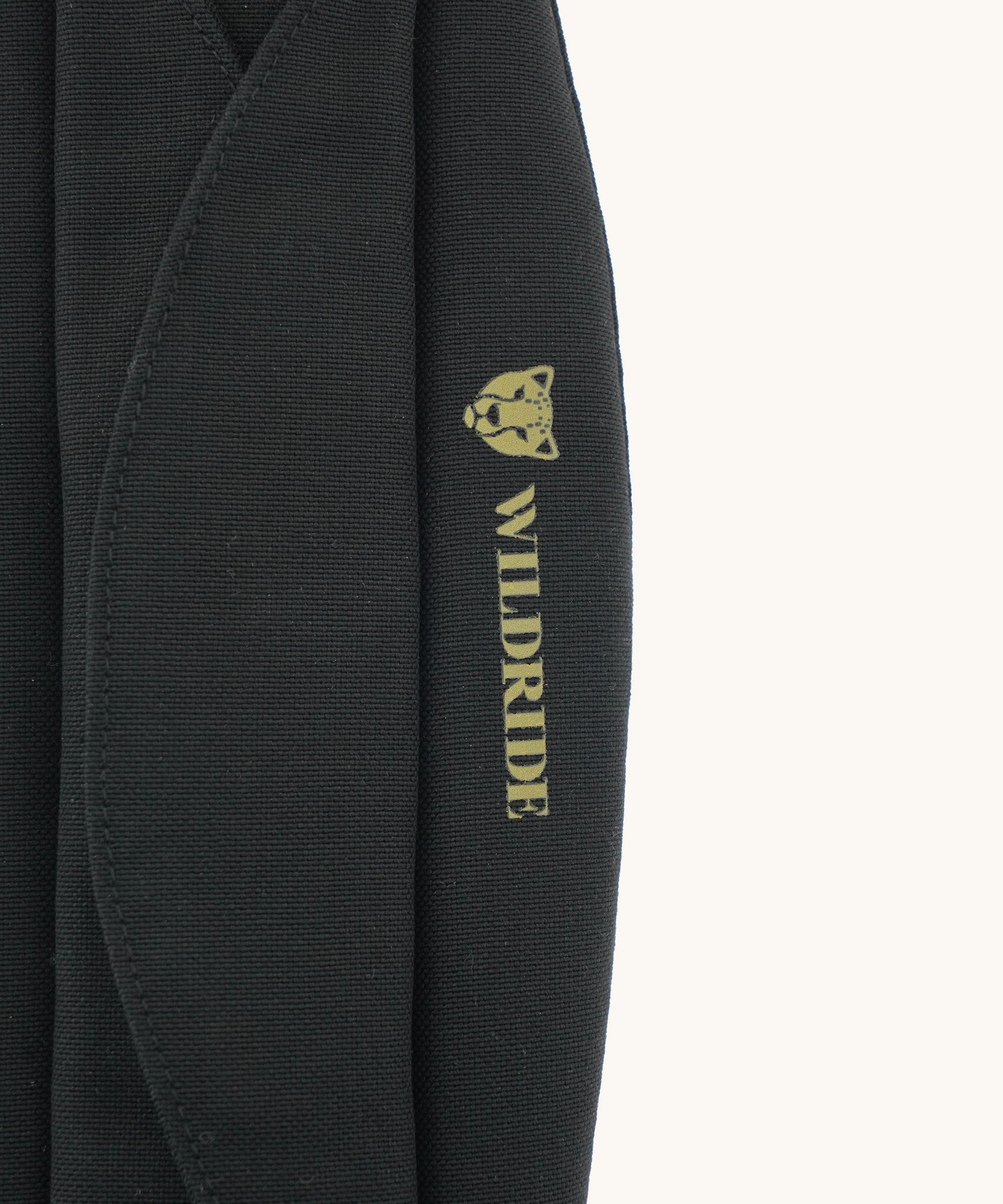 A close up of the Wildride premium shoulder pad in black available at Babipur showing the velcro and brand logo detail