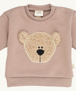 A close up of the Wooly Organic embroidered sweater in pale blush pink /savannah available at Babipur showing the cute fluffy teddy bear embroidery on the front and popper fastener detail