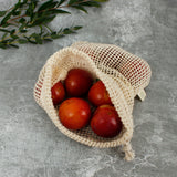 A Slice Of Green small mesh produce bag made from recycled cotton showing an opened bag with a bunch of red apples inside showing scale