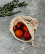A Slice Of Green small mesh produce bag made from recycled cotton showing an opened bag with a bunch of red apples inside showing scale