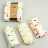 A Slice Of Green rainbow muslin cloth set rolled up and showing the fruit print detail on organic cotton fabric.