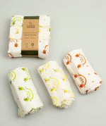 A Slice Of Green rainbow muslin cloth set rolled up and showing the fruit print detail on organic cotton fabric.