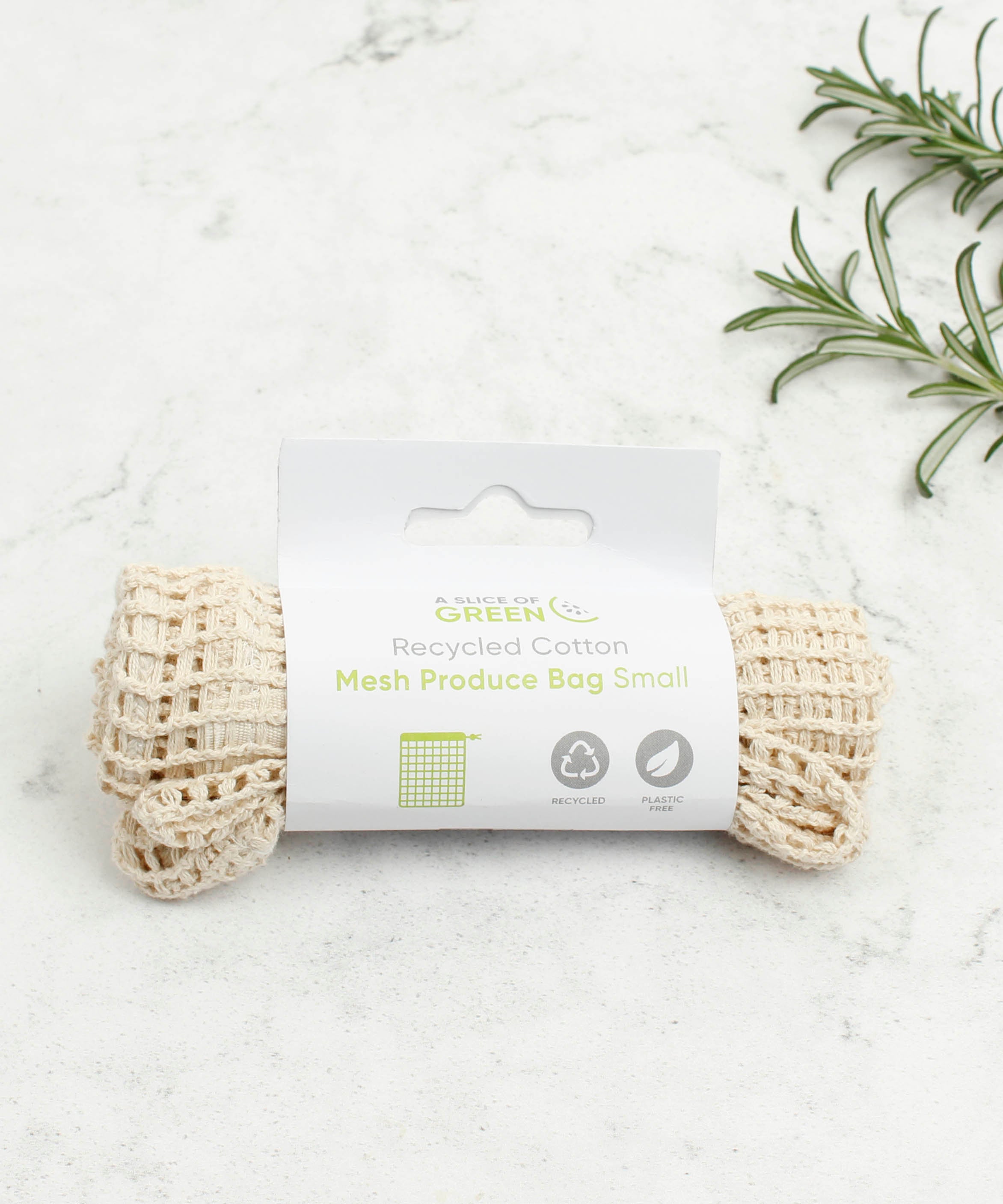 A Slice Of Green small mesh recycled cotton produce bag laid flat on a stone surface.