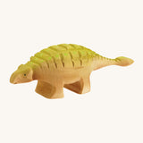 Big wooden Bumbu green and light brown Ankylosaurus on a cream background