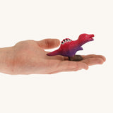 Pink and purple standing baby spinosaurus on a hand