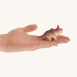 Light and dark brown with spots standing baby triceratop on a hand