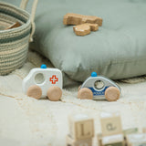 The Bajo ambulance and police car from the emergency vehicle set placed on a rug. These heirloom quality toys by Bajo are part of a wide range of wooden toys available here at Babipur.