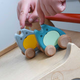 A child's hand holding two Bajo wooden push along ghost toys on a Triclimb Miri slide ready to let go of them and let them slide down.
These heirloom quality wooden toys are part of a wide range available here at Babipur.