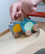 A child's hand holding two Bajo wooden push along ghost toys on a Triclimb Miri slide ready to let go of them and let them slide down.
These heirloom quality wooden toys are part of a wide range available here at Babipur.