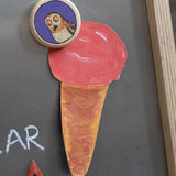 A close up of a Bajo gruffalo owl magnet stuck onto a Triclimb biri board. These magnets are part of a range of Bajo wooden toys available at Babipur.