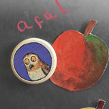 A close up of a Bajo gruffalo owl magnet stuck onto a Triclimb biri board. These magnets are part of a range of Bajo wooden toys available at Babipur.