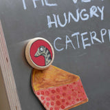 A close up of a Bajo gruffalo snake magnet stuck onto a Triclimb biri board. These magnets are part of a range of Bajo wooden toys available at Babipur.