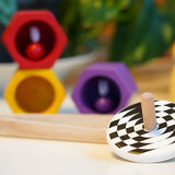 Bajo kids wooden latern spinning top on a white table next to some PlanToys Bee toys