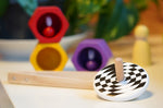 Bajo kids wooden latern spinning top on a white table next to some PlanToys Bee toys
