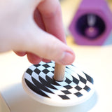 Close up of a hand spinning the Bajo children's wooden latern spinning top