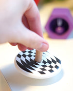 Close up of a hand spinning the Bajo children's wooden latern spinning top