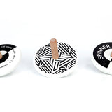 3 Bajo plastic-free black and white wooden spinning top toys on a white background