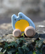 A blue and yellow coloured Bajo wooden push along ghost toy placed on a stone wall outdoors.
These heirloom quality wooden toys are part of a wide range available here at Babipur.