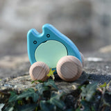 A turquoise coloured Bajo wooden push along ghost toy placed on a stone wall outdoors.
These heirloom quality wooden toys are part of a wide range available here at Babipur.