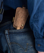 The Bambu Bamboo Utensil Travel Set with Cork Fabric Pouch shown in a person's back pocket of a pair of denim jeans