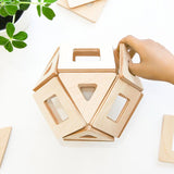 Close up of a hand placing a Big Future Toys earth tile into a geometric ball shape on a white background